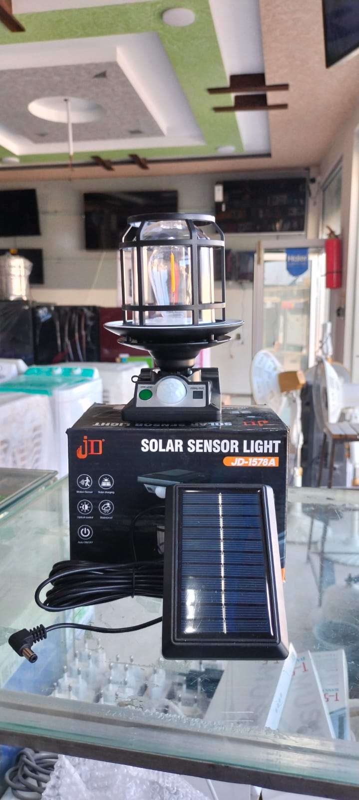 The JD-1578A Solar Sensor Light is an outdoor wall lamp featuring a built-in motion sensor, dual solar charging capability, and adjustable warm/white LED lighting modes.
